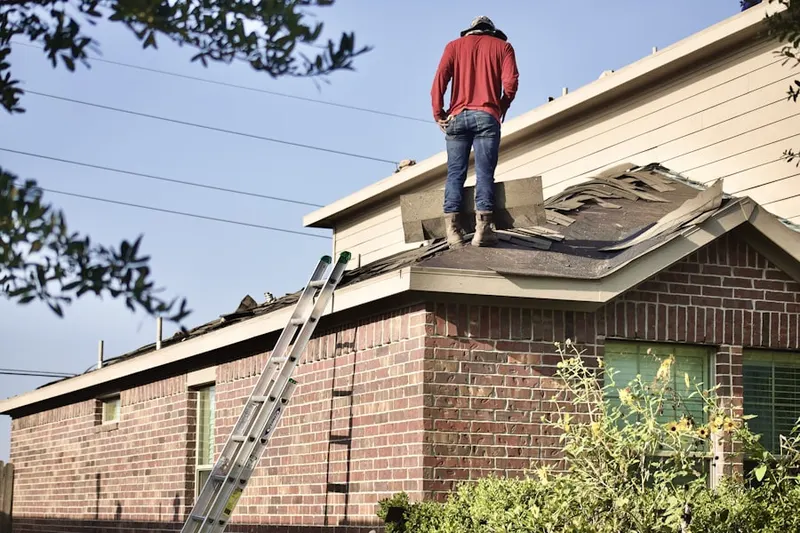Professional roofer working on a residential roof in Winding Ways